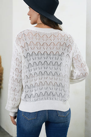 White openwork knit cardigan with balloon sleeves and diamond pattern.