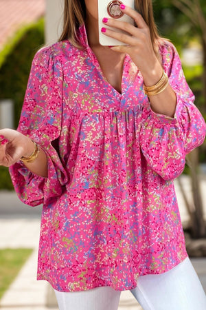 Hot pink graphic mesh sleeve blouse with v-neck and gathered waist.
