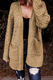 Textured open-knit pocket cardigan in caramel acrylic with a V-neck and long sleeves.