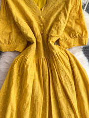 Yellow lace-embellished A-line midi dress with button front and puff sleeves.