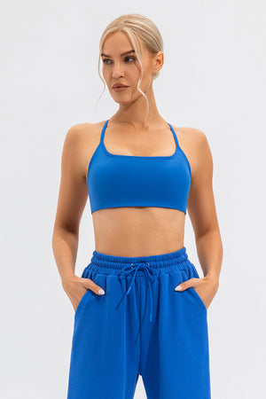Blue sports bra with square neckline and thin straps, paired with matching sweatpants.