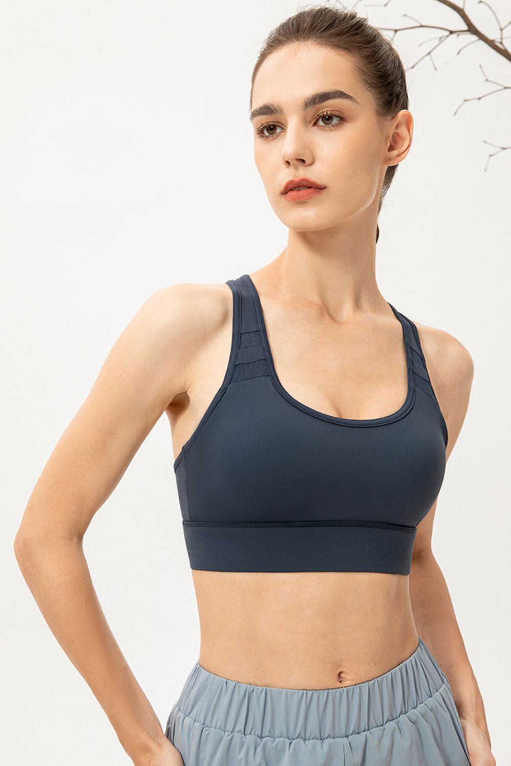 Mesh-inset performance sports bra in Deep Teal with scoop neck and racerback straps.