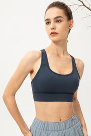 Mesh-inset performance sports bra in Deep Teal with scoop neck and racerback straps.