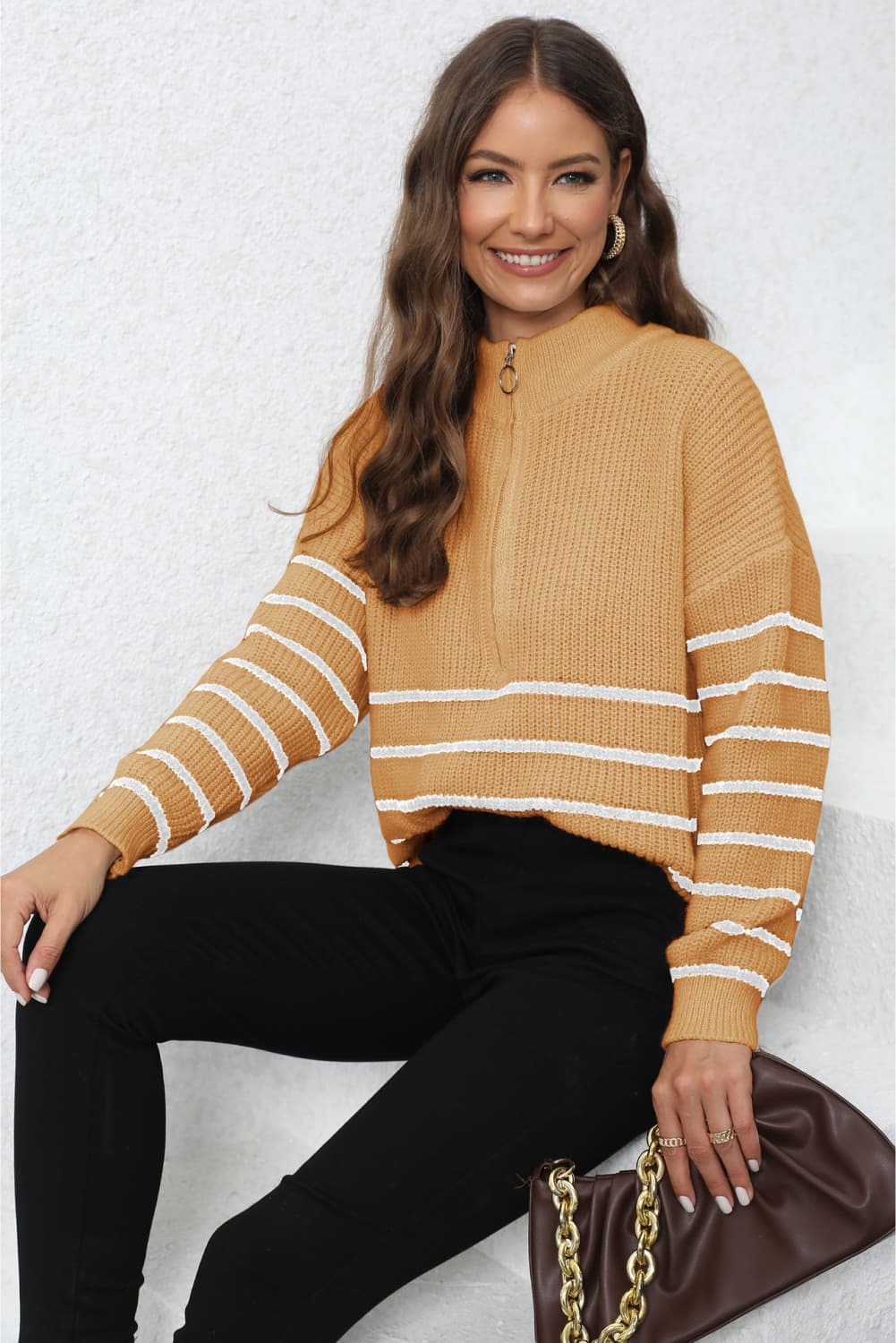 Tangerine ribbed knit quarter-zip sweater with white stripes on sleeves and body.