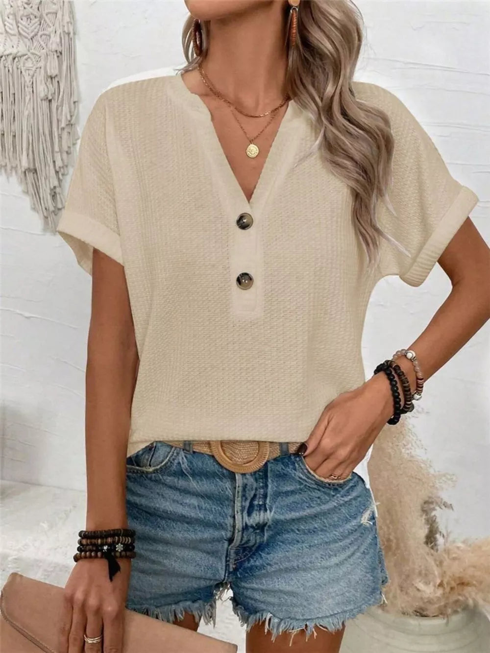 Apricot waffle knit V-neck t-shirt with button detail and cuffed sleeves.