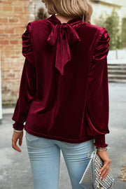 Burgundy velvet blouse with puff sleeves and back bow detail