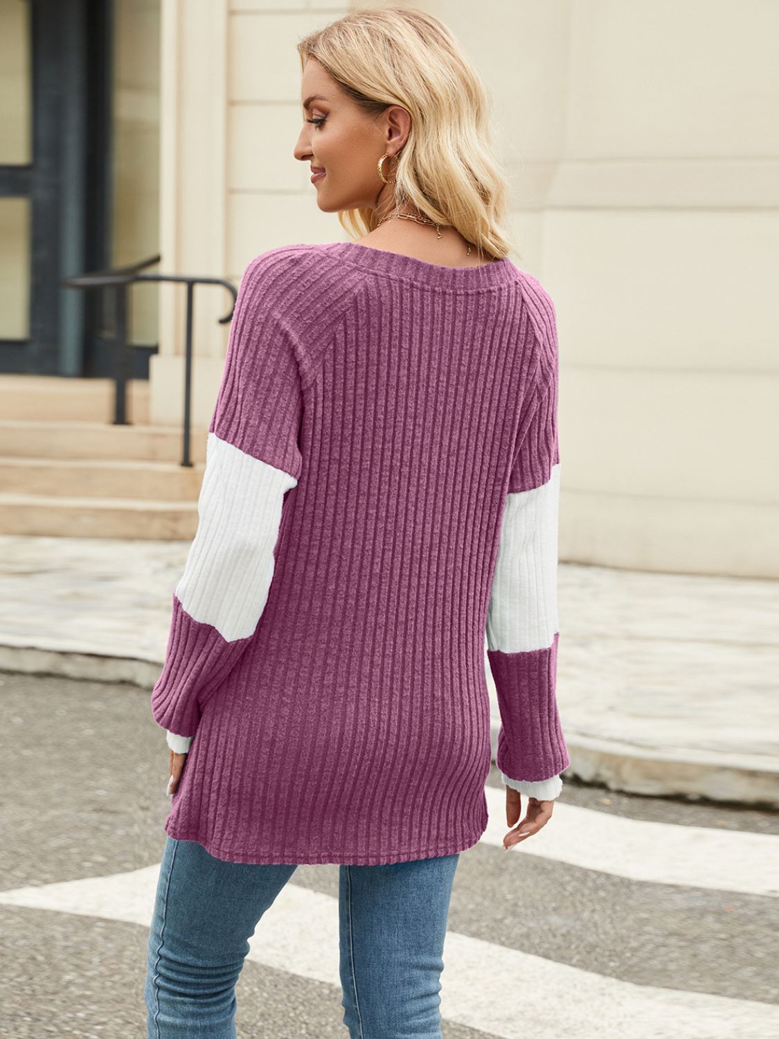 Ribbed knit henley sweater in plum with white colorblock sleeves and crew neck.