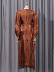 Brown satin maternity maxi dress with ruched bodice and balloon sleeves.