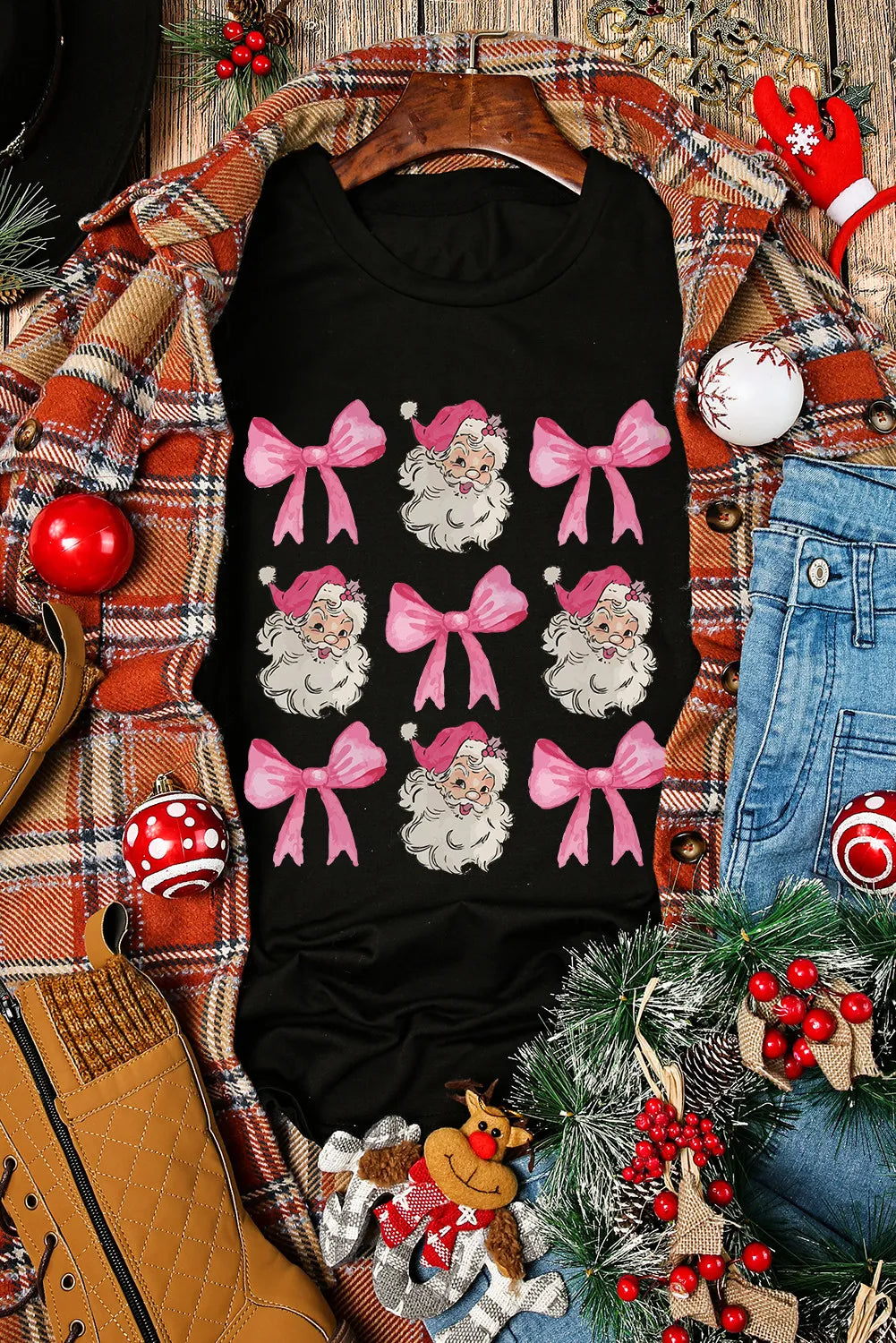 Black t-shirt with a repeating pattern of Santa Claus faces and pink bows.