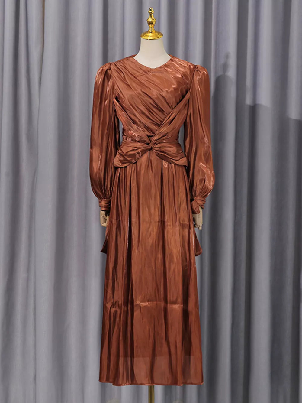 Brown twisted draped maxi dress with ruched bodice and long sleeves.