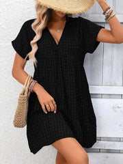 Black plaid V-neck mini dress with short sleeves and tiered hem.