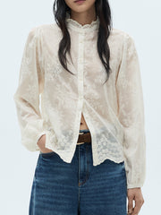 Sheer apricot button-down shirt with floral embroidery and ruffled collar.