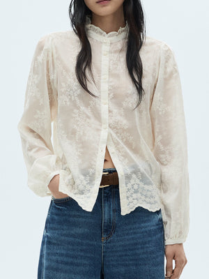 Sheer apricot button-down shirt with floral embroidery and ruffled collar.