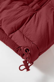 Burgundy quilted puffer vest detail showing adjustable drawcord hem with toggle.