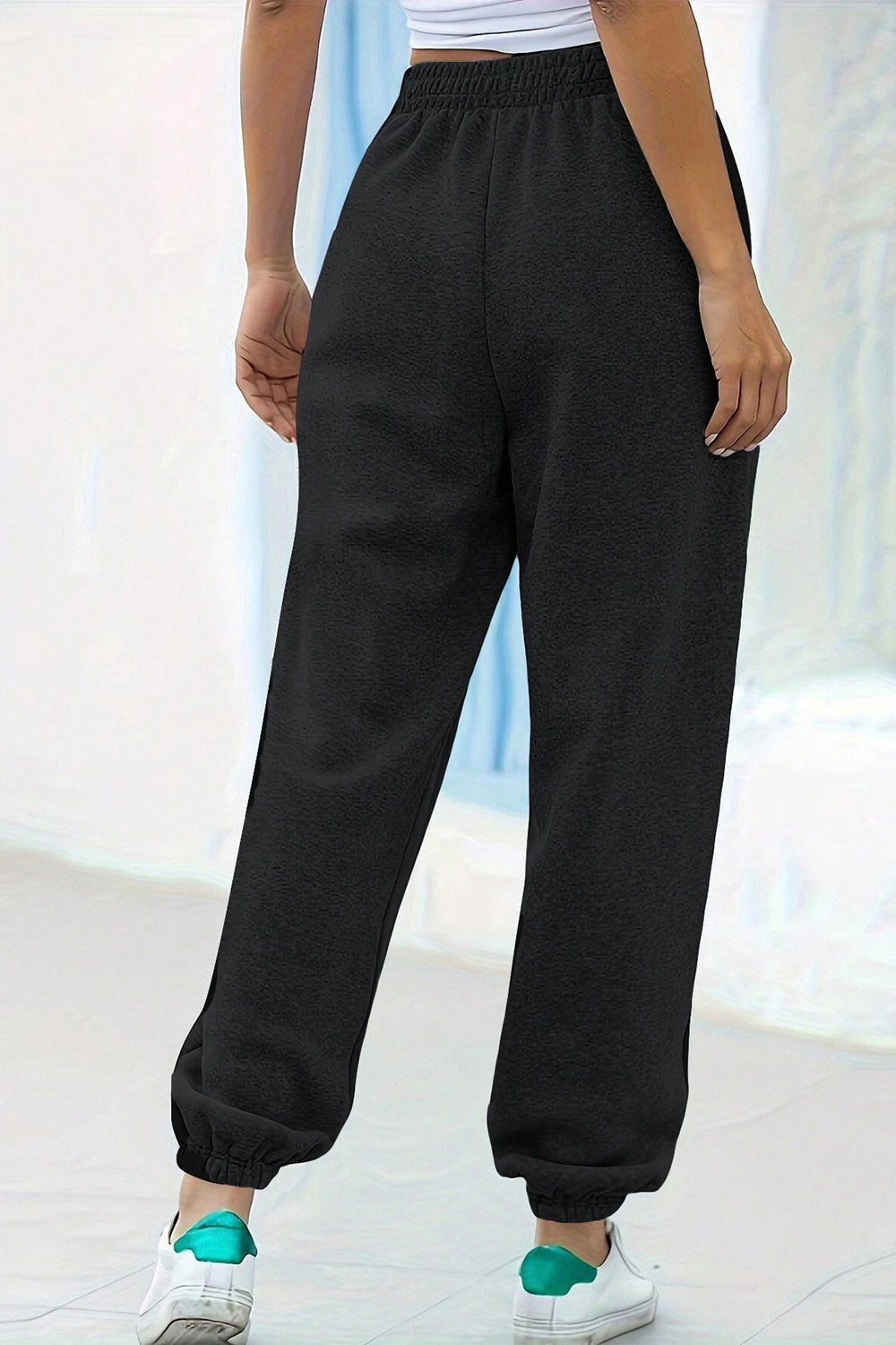 Black relaxed-fit cuffed sweatpants with an elastic waistband and textured fabric.
