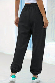 Black relaxed-fit cuffed sweatpants with an elastic waistband and textured fabric.