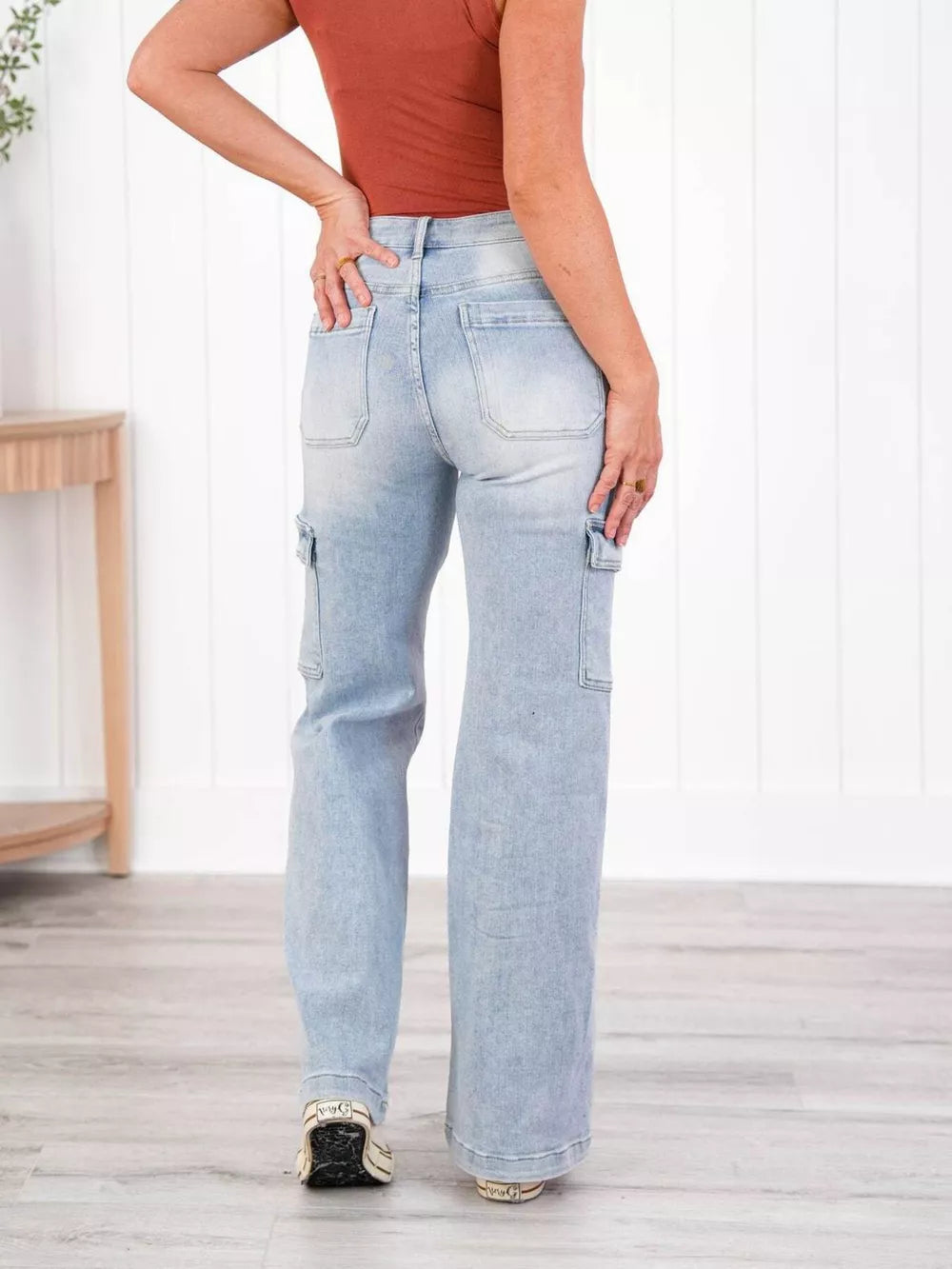 Light wash denim wide-leg cargo jeans with utility pockets and a relaxed fit.