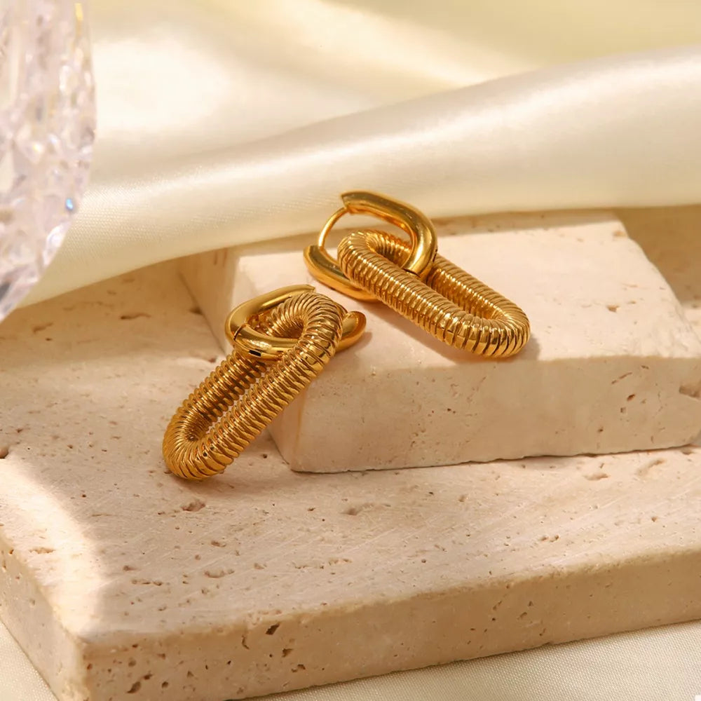 Gold link drop earrings with textured oval pendant and smooth hoop.