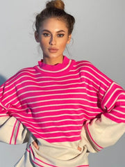 Colorblock stripe knit sweater with bell sleeves and mock neck in pink and cream.