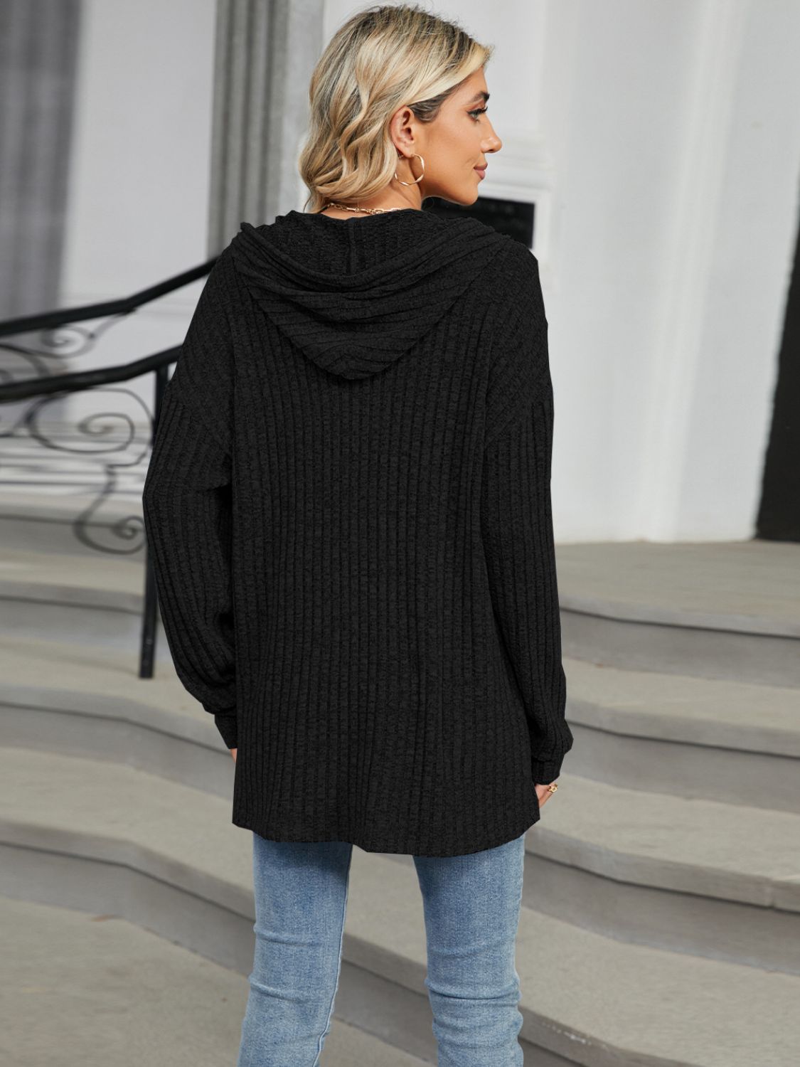 Black ribbed knit henley hoodie with a hood and button detail.
