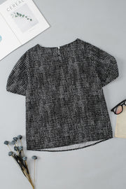 Black micro-dot puff sleeve blouse with round neckline and back keyhole closure.