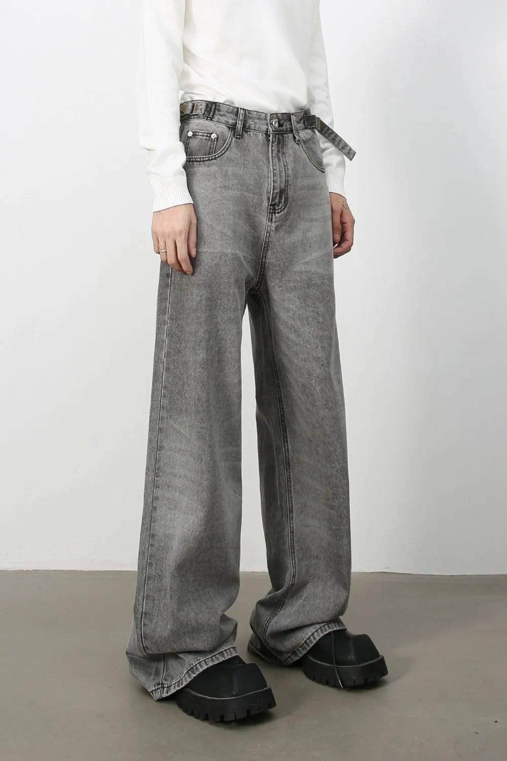Wide-leg dark gray washed denim jeans with belt and a relaxed fit.