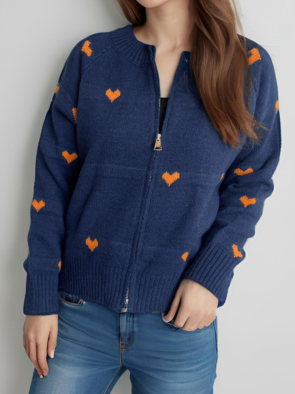 Dark blue zip-through knit cardigan with allover orange heart appliqué and ribbed cuffs.