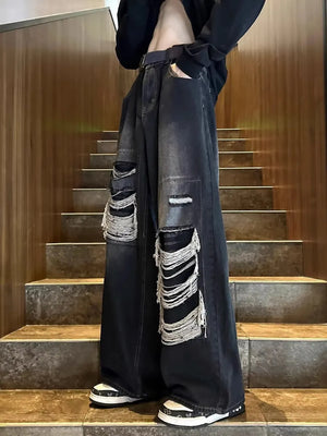 Relaxed fit black distressed jeans with ripped details and wide leg.
