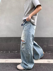 Distressed wide-leg jeans in light wash denim with pocket detail and ripped knees.