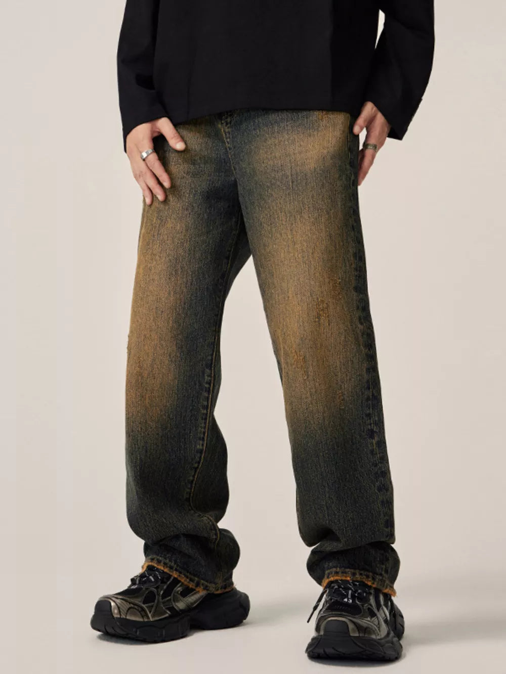 Men's relaxed fit jeans in vintage wash denim with distressed details.