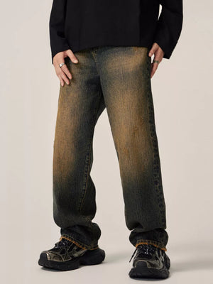 Men's relaxed fit jeans in vintage wash denim with distressed details.