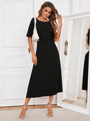 Black midi dress with short sleeves, A-line cut, and a keyhole back detail.
