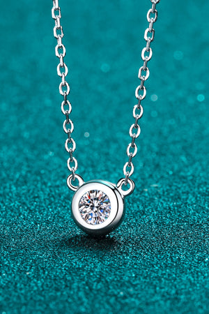 Silver solitaire diamond necklace with bezel-set pendant on a delicate chain.
