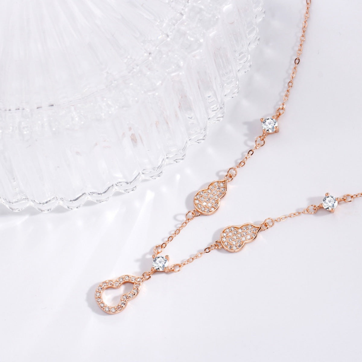 Rose gold Y-lariat necklace with zircon-adorned gourd charms and cubic zirconia.