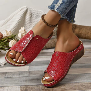 Red glossy crocodile-embossed wedge sandals with open toe and white stitching detail.