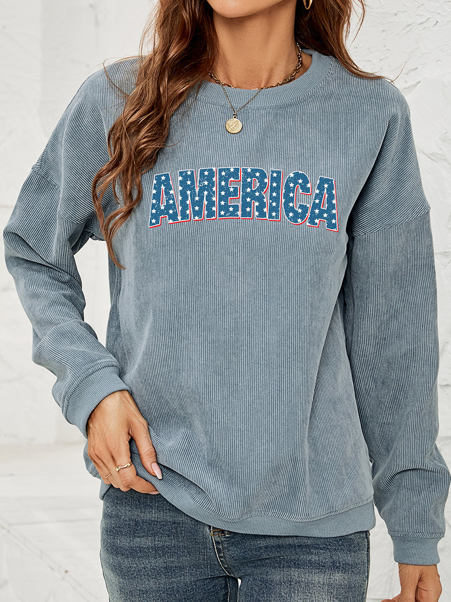 French Blue corduroy sweatshirt with "AMERICA" graphic in stars and stripes pattern.