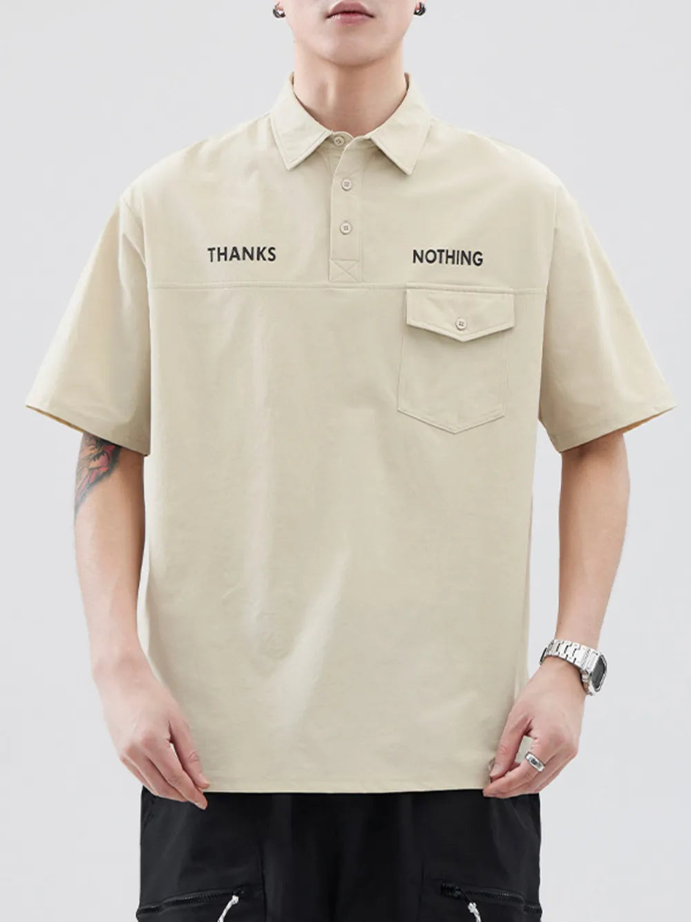 Apricot polo shirt with button detail, chest pocket, and "THANKS NOTHING" text.