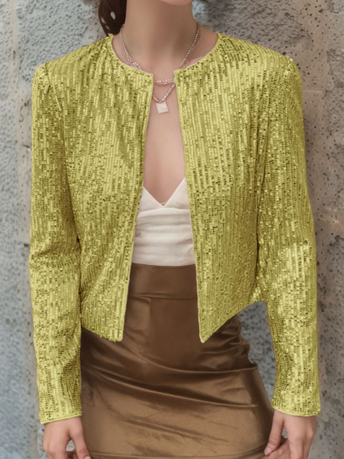 Champagne sequin bolero jacket with round neckline and long sleeves, worn open over a white top.
