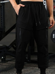 Black technical joggers with zip pockets and drawstring waist.