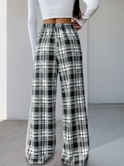 Black plaid wide-leg track pants with elastic waist and side stripe detail.