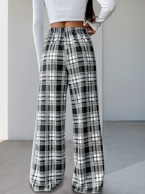 Black plaid wide-leg track pants with elastic waist and side stripe detail.