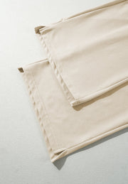 Beige wide-leg drawstring trousers showing hem detail