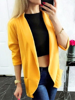 Open-front gold blazer with rolled sleeves and pockets, styled casually.