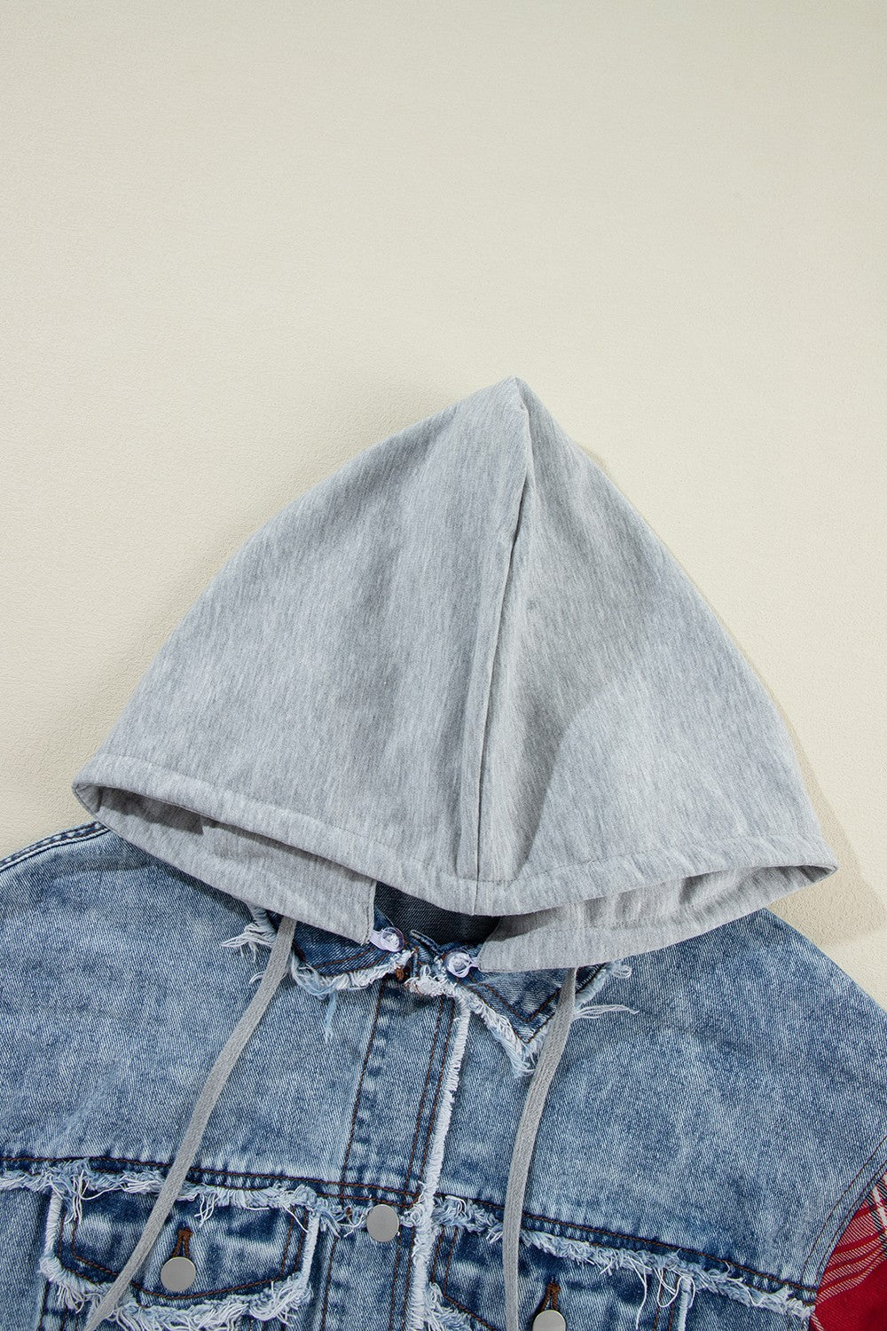 Denim hooded jacket with distressed details and grey drawstring hood.