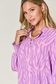 Lavender zebra print blouse with shirred cuffs and a collared neckline.