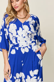 Royal blue floral kimono jumpsuit with wrap v-neck and wide leg pants.