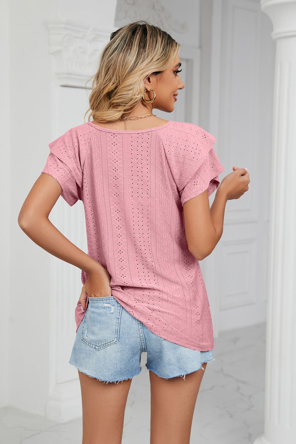 Blush pink eyelet knit blouse with flutter sleeves and V-neck, shown from the back.