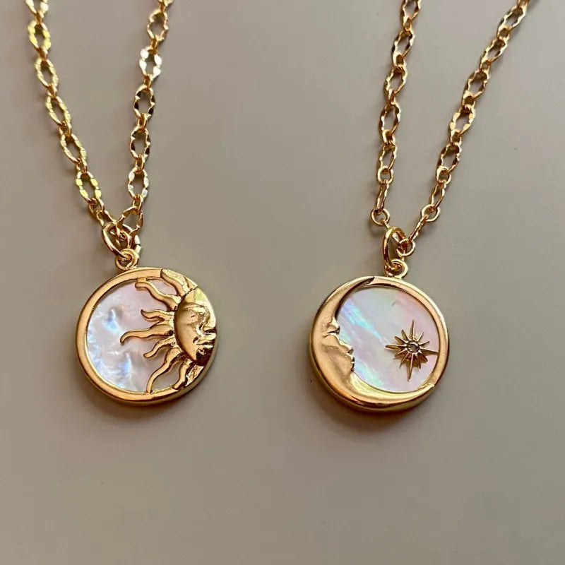 Gold sunburst medallion chain necklace and moon with star pendant on mother of pearl