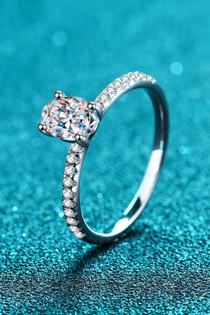 Silver moissanite ring with pavé band and oval center stone.