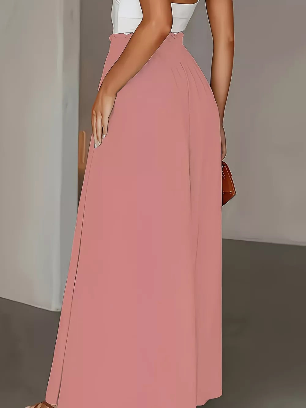 Pale blush wide-leg pants with paperbag waist and a flowing silhouette.